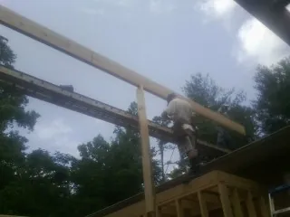 Carpenter setting a ridge beam over a new addition frame — Ice Dam Removal by Roofing Brothers in Lorimor