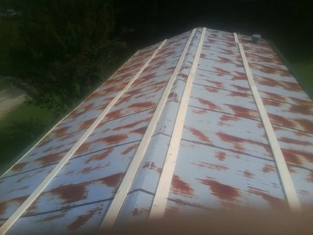 Rusted metal roof panels with new wood purlins before replacement — Storm Damage Roof Repair in Lorimor by Roofing Brothers