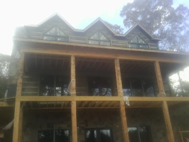 Dormers and porch framing on a large log home under construction — Roof Coating work by our crew in Lorimor