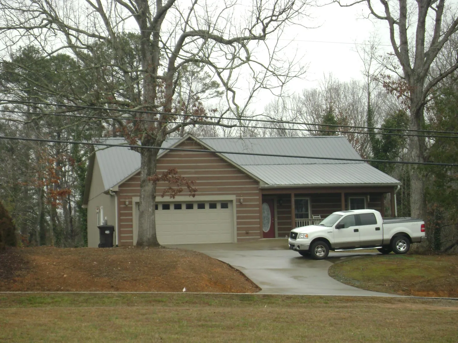 Gray metal roof on a log sided house with an attached two car garage in Lorimor